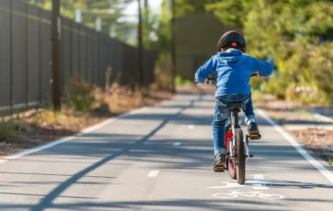 Boy learning to ride a bike on a bike path