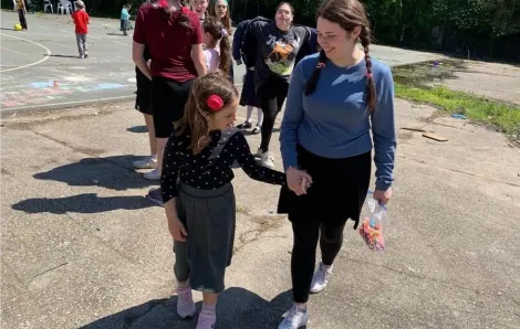 A student from Northwest Yeshiva High School walks hand in hand with a young Ukrainian girl