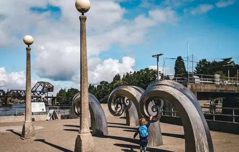 Young kids play by the wave sculptures at Seattle's Ballard Locks among great play destinations for toddlers and preschools while big kids are in school