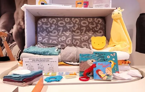A Scottish "baby box" given to new parents in Finland is on display at Seattle's Gates Foundation Discovery Center new exhibit called Designing Motherhood, things that make and break our births