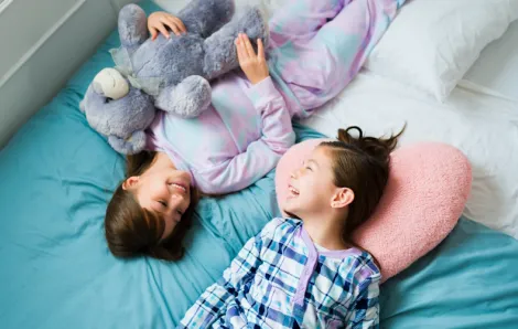 Two girls smiling and laughing at a sleepover