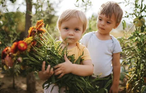 Two children holding flowers from a local flower farm