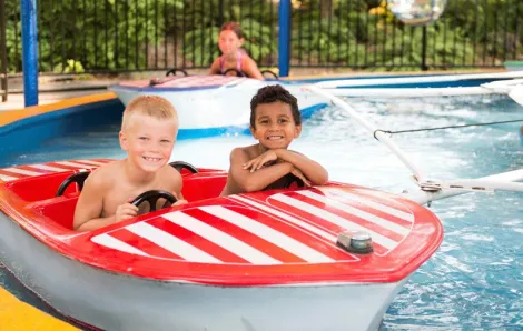 Two kids on a red and white striped boat at Water Waves Theme and Water Park in Federal Way near Seattle