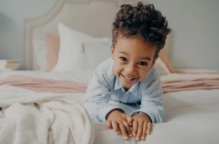 Child in a bed happy about getting better sleep