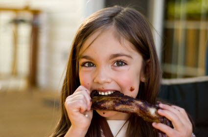 Little girl eating ribs