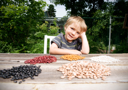 Little boy with his seed and bean collection from family garden