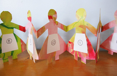 Homemade Christmas paper doll chain advent calendar by The Artful Parent
