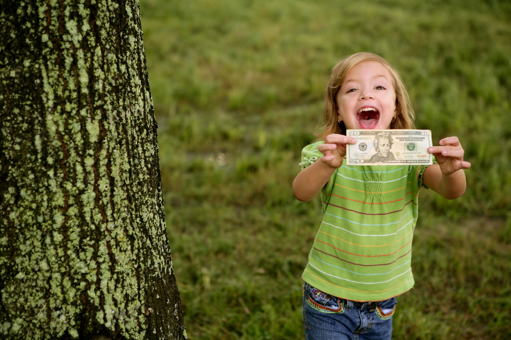 little girl with money outside in a park