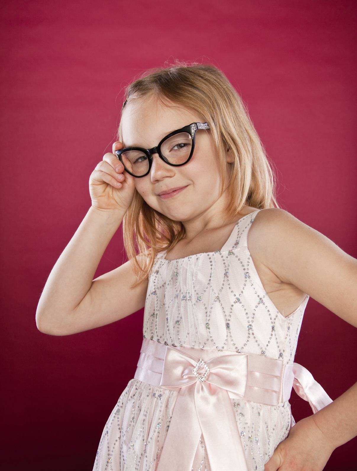 little girl with glasses looking sly