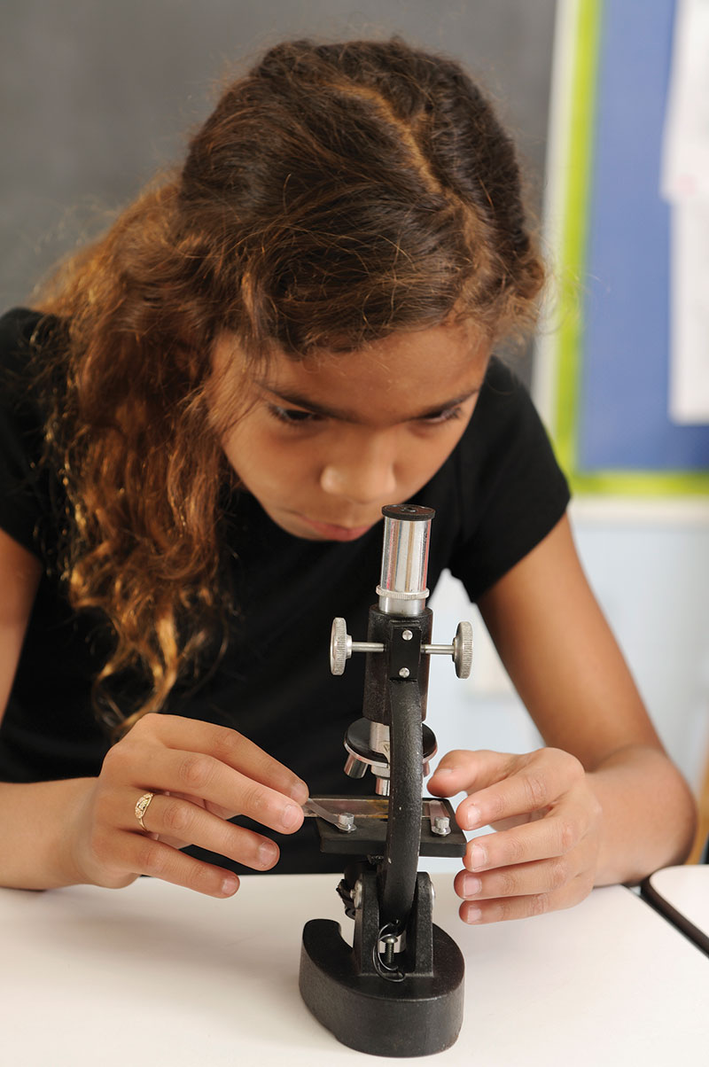 middle school girl using microscope STEM