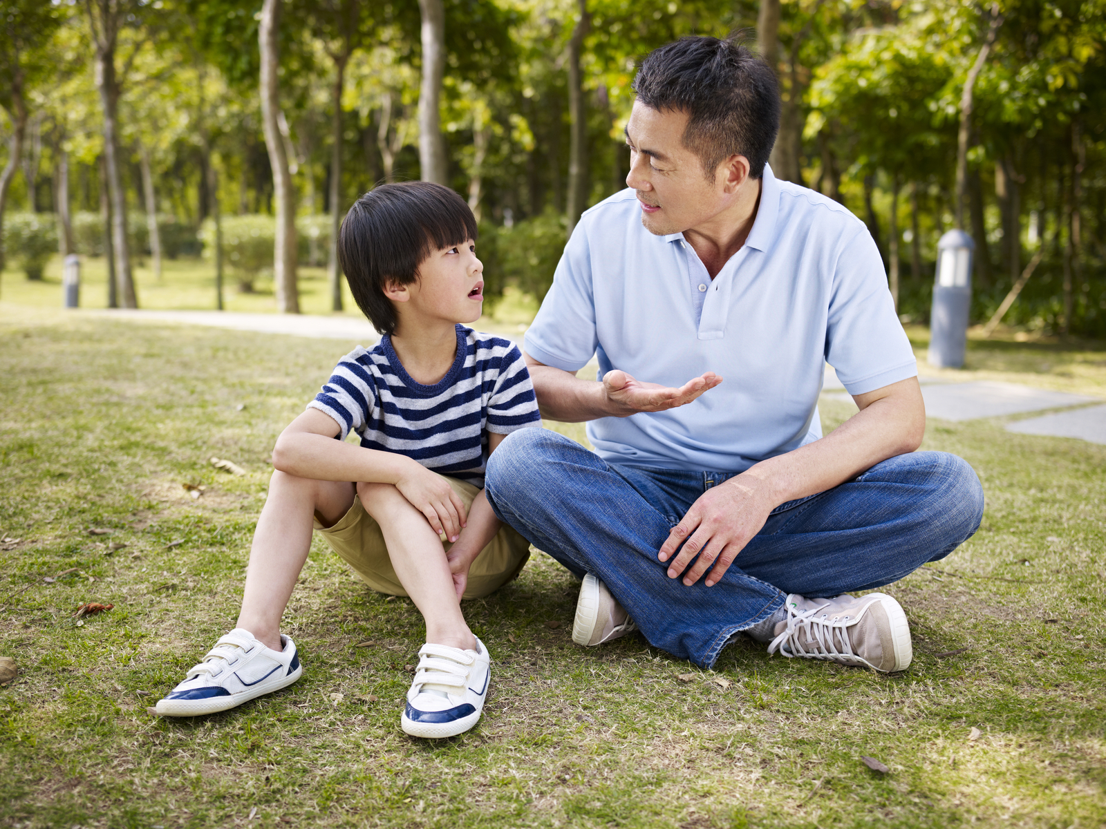 father and son talking in park
