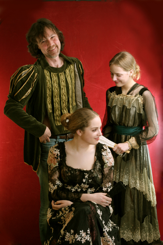 actors in shakespearian costume in front of red backdrop