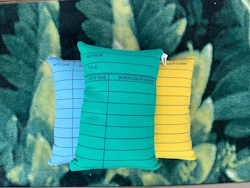 "Green, blue and yellow library card pillow"