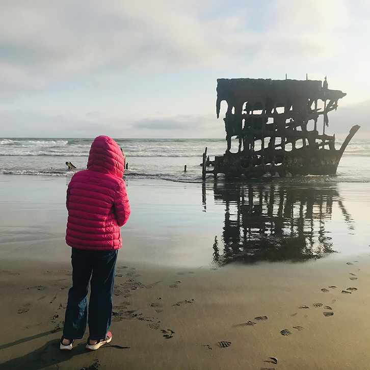 A visitor to Cannon Beach, Oregon, visits the Peter Iredale shipwreck at Fort Stevens State Park.