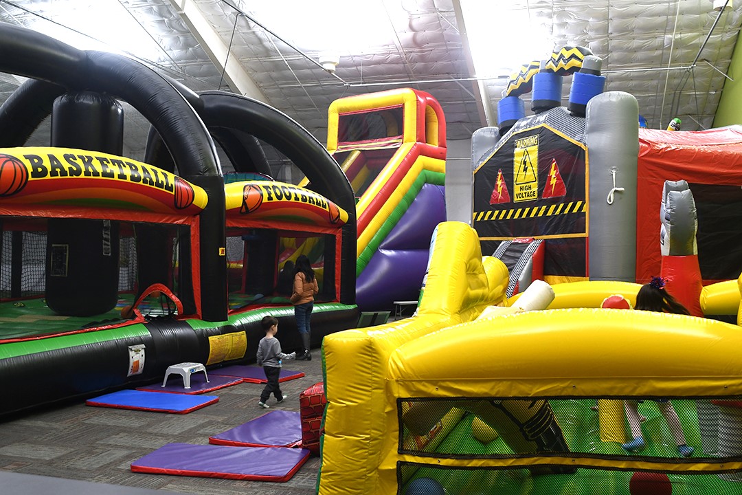 Kids play on the inflatables and bouncy house toys at Arena Sports’ new family entertainment center in Issaquah, Wash., near Seattle