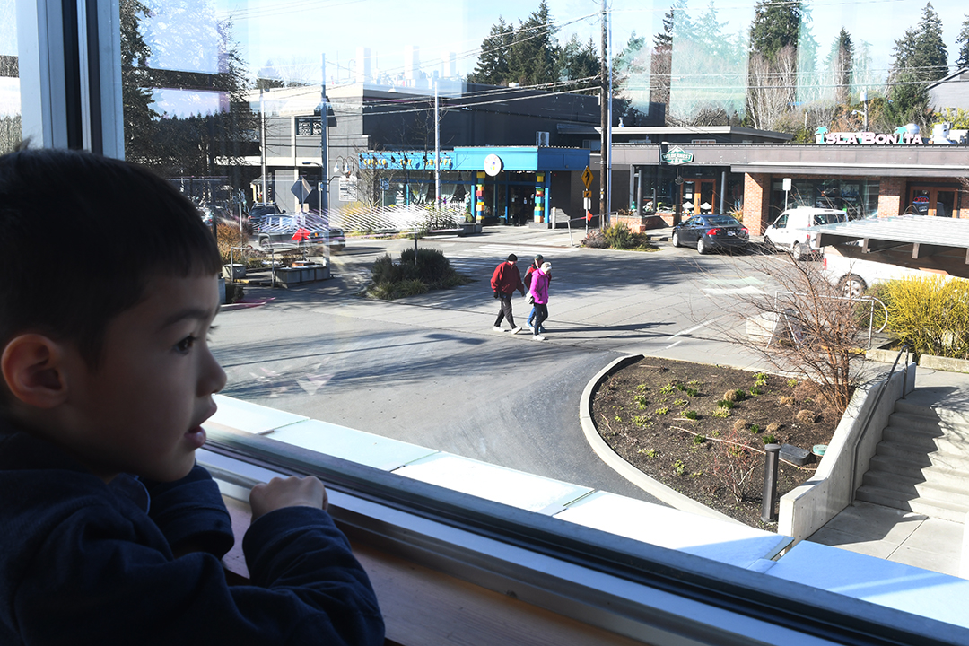A young boy looks out the window from the second floor dining area at Winslow's Town & Country Market on Bainbridge Island