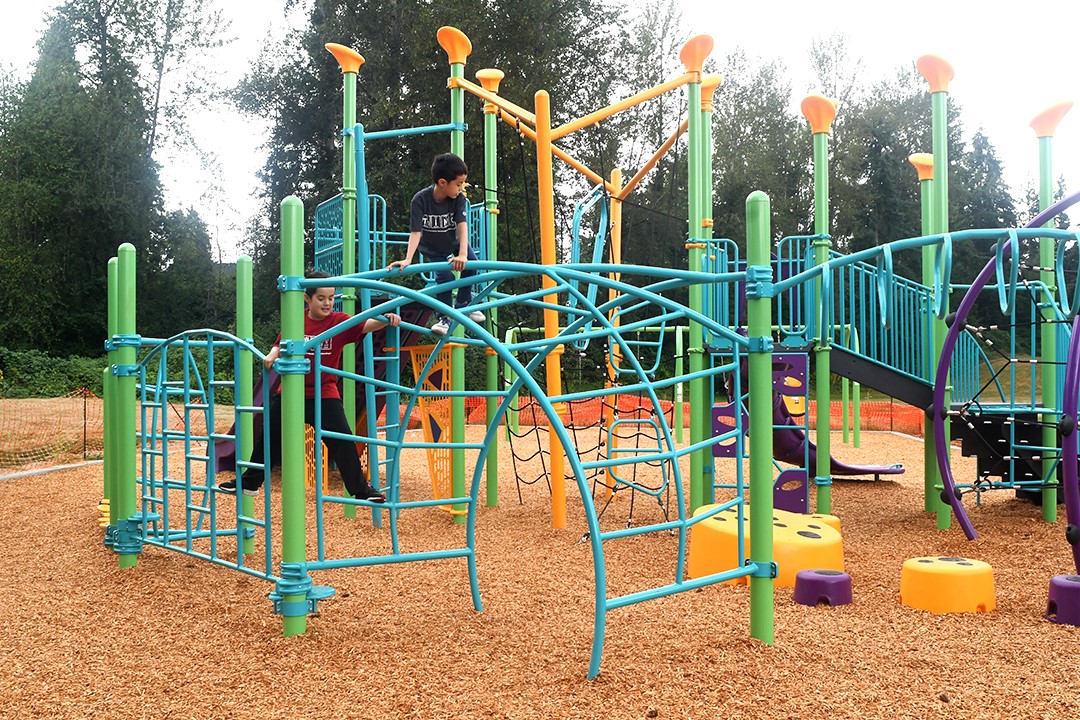 Kids play on Cascade Park new playground equipment
