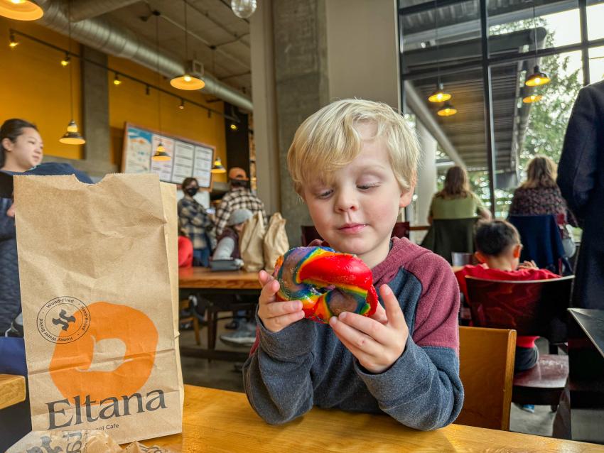 Child at Eltana with rainbow bagel