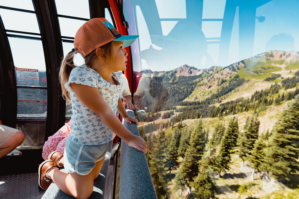 A young girl looks out from the Mt. Rainier Gondola at Crystal Mountain in summer