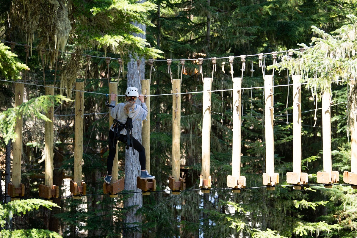 A girl navigates the Flying Raven Adventure Course at Crystal Mountain, among summer activities at the ski area