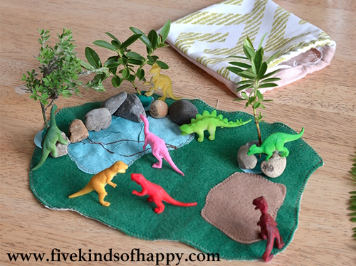 "Felt dino mat with plastic dinosaurs and trees"