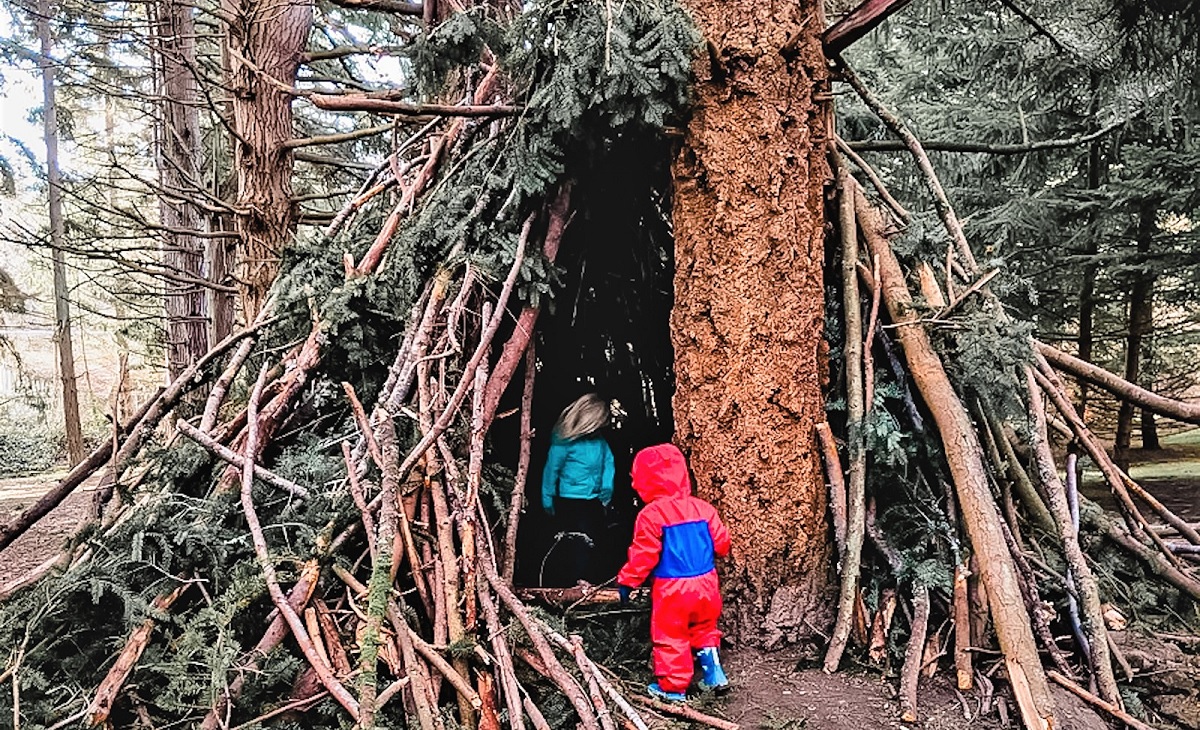 Kids peer into a large tree fort found near the playground at Seattle’s Discovery Park, one of the Seattle area’s largest and best parks