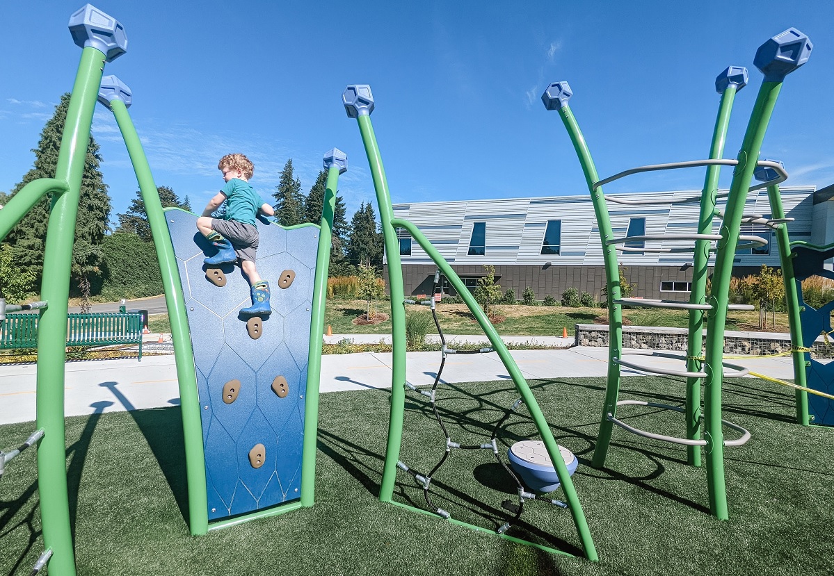 Young boy on a small climbing wall at the new playground at Emma Yule Park in Everett