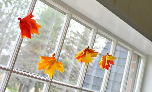 "Fall Fairies made of tissue paper hanging in a window"