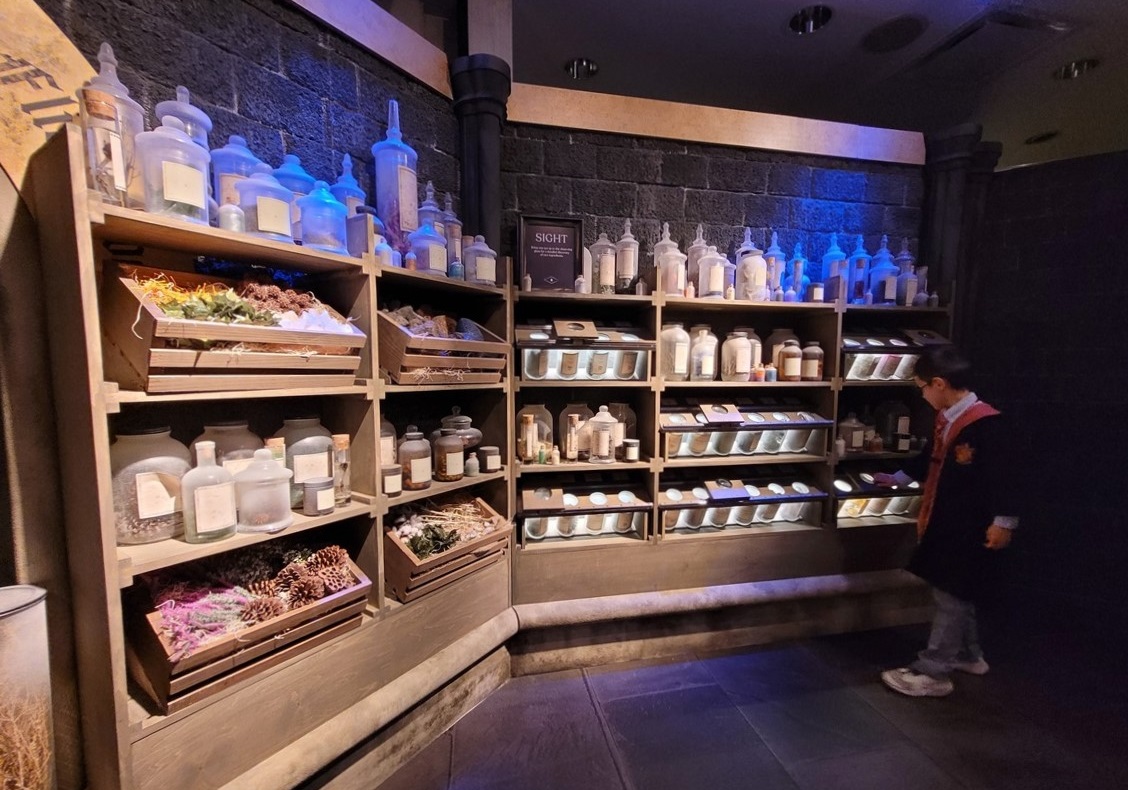 At Harry Potter: Magic at Play in Seattle a boy inspects a wall of potion ingredients