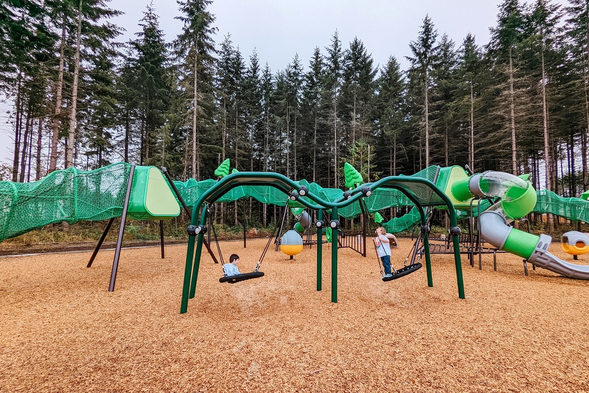 Kids on disc swings at Hawks Landing new playground in Bonney Lake, Wash, near Seattle 