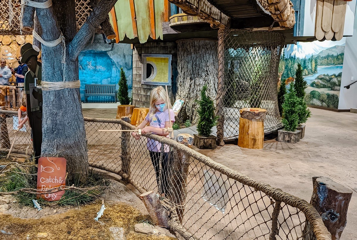 A girl plays in the catch-and-release pond fishing area of Imagine Children's Museum's new expansion