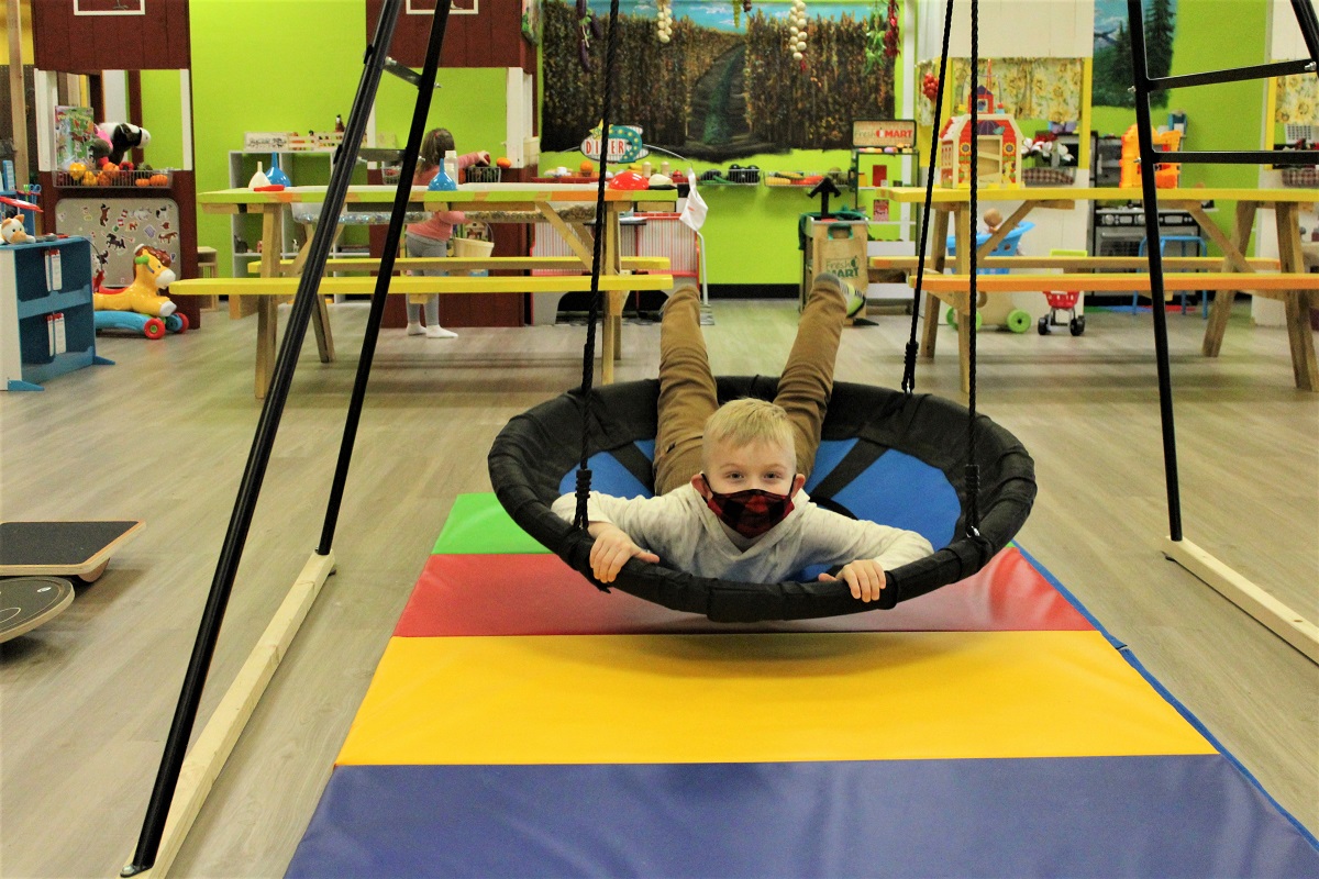 A boy plays in a disc swing at Kaleidoscope Family Gym in Puyallup among great indoor play spaces for kids and families on rainy days in and around Seattle