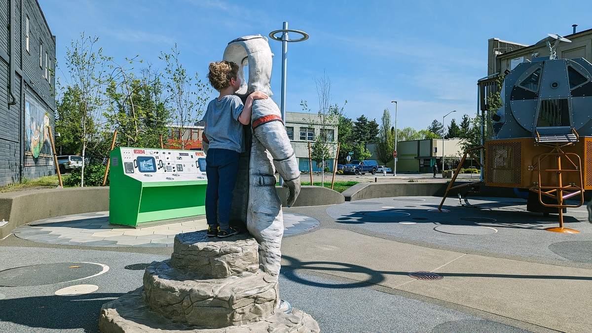 A boy peers through an astronaut's open helmet at a selfie station at Kent's updated Kherson Park