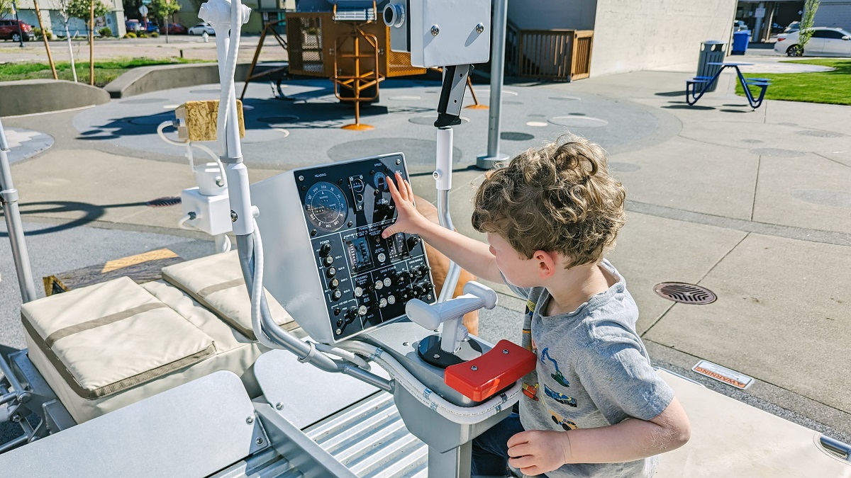 A young boy works on the control panel of Kherson Park's new lunar rover play piece