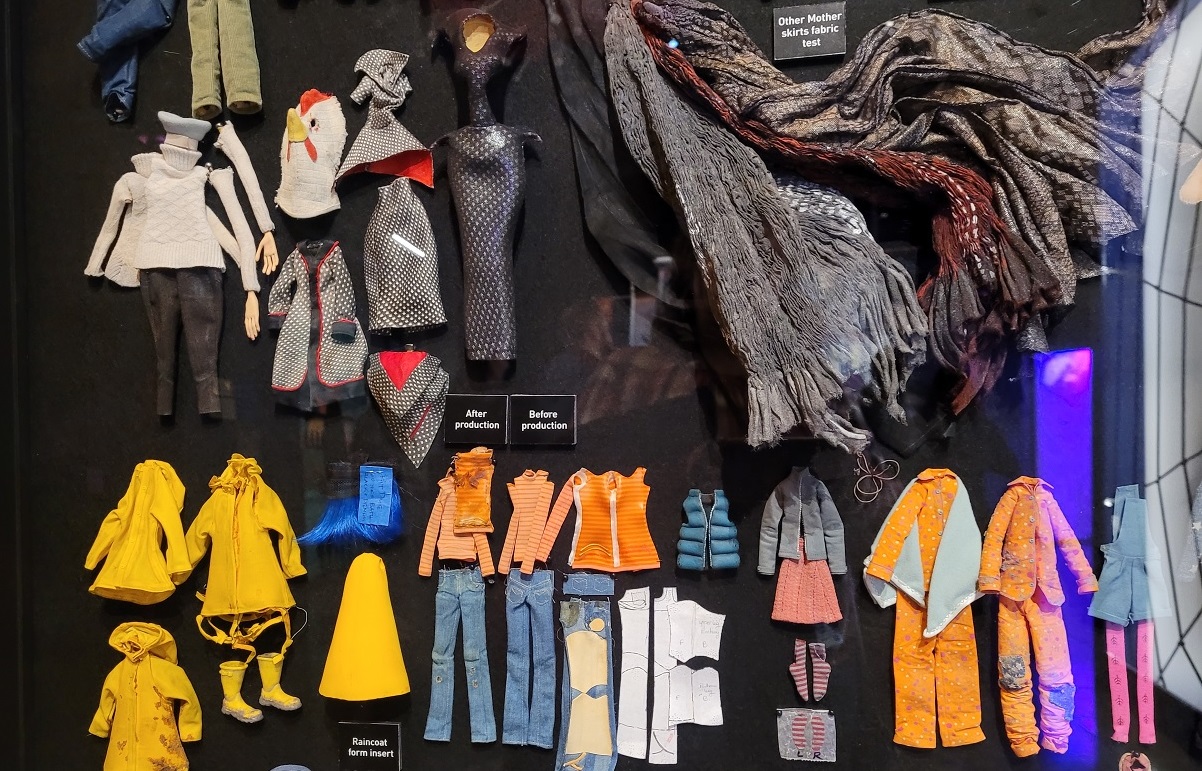 A selection of some of the Coraline puppet's costumes on display at Hidden Worlds: The Films of LAIKA at Seattle's Museum of Pop Culture
