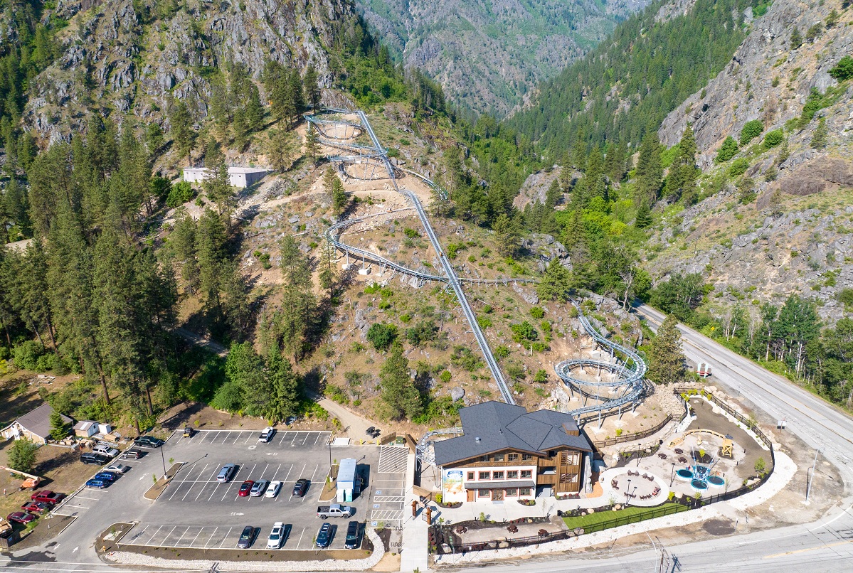 Overhead drone view of the new hillside Leavenworth Adventure Park featuring an alpine coaster, climbing wall, bungie trampoline jumper and sluicing activity