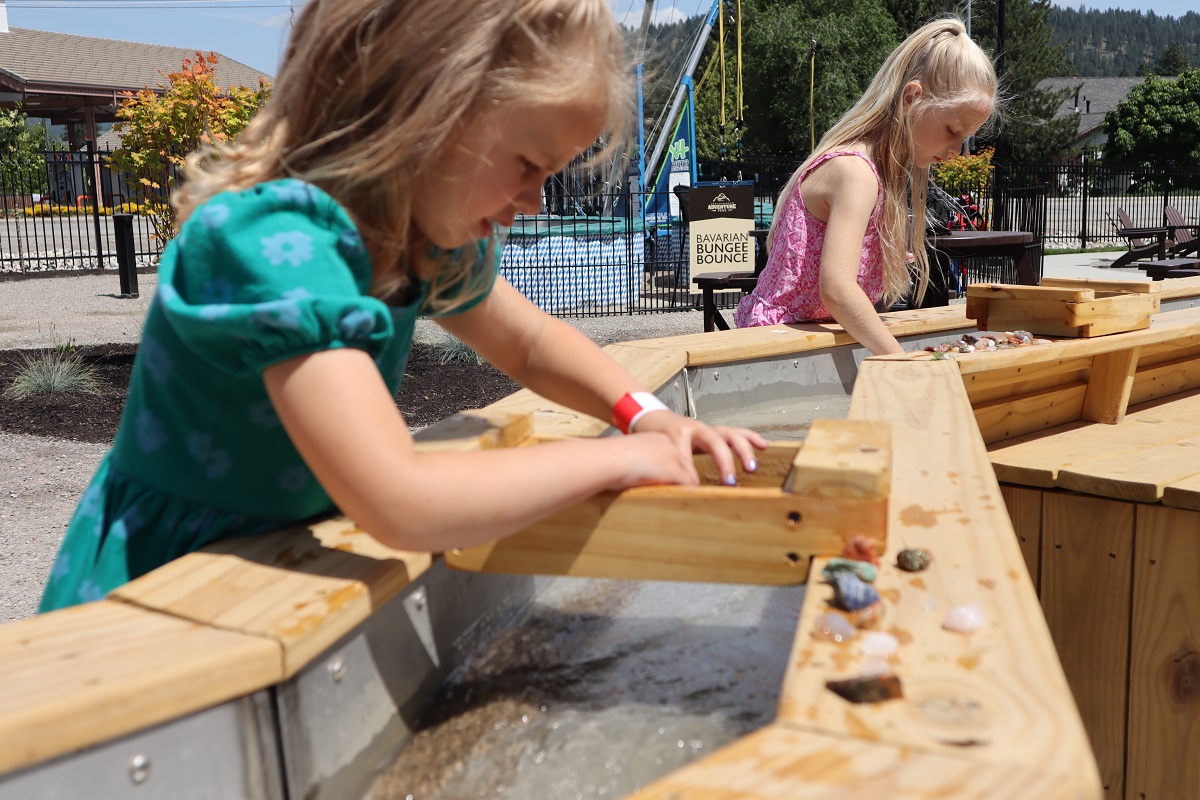 Girls lean over a trough at the sluicing activity at Leavenworth Adventure Park