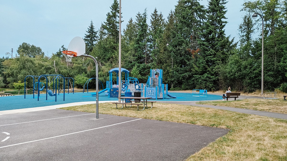 A basketball court at Meadowdale Playfields entertains older kids while younger kids can play on the accessible new playground