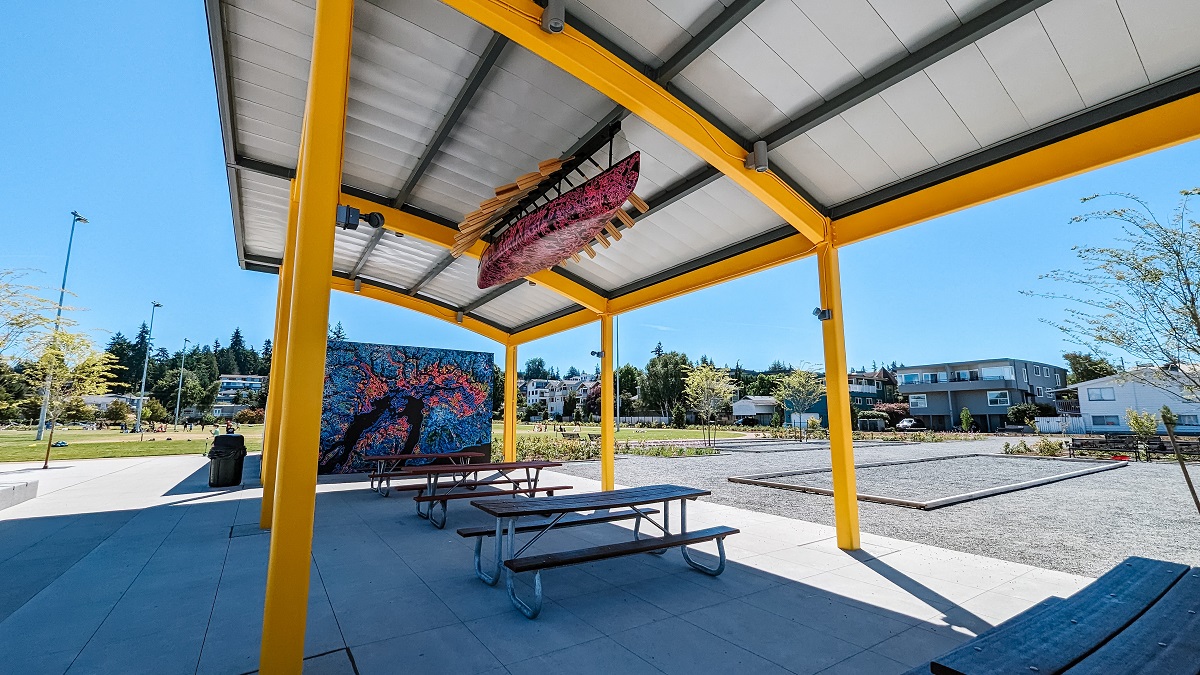 A large covered picnic shelter at the newly renovated Civic Center Playfield in Edmonds features a decorated canoe as art