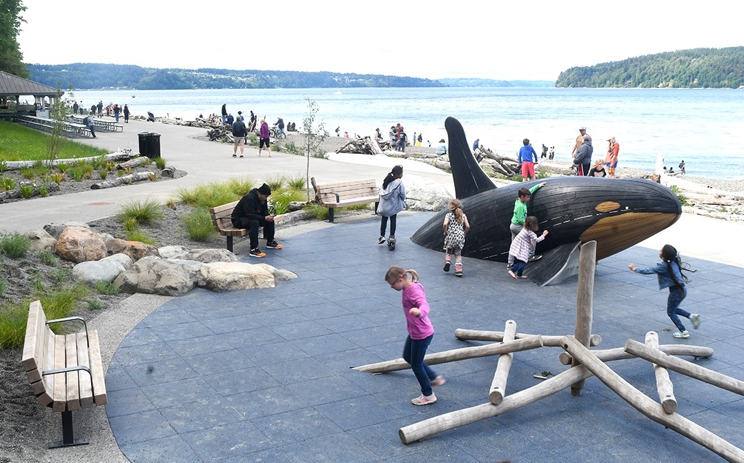 A child plays on the orca whale sculpture play structure at newly reopened Owen Beach in Tacoma’s Point Defiance Park best free things to do in Seattle with kids this summer