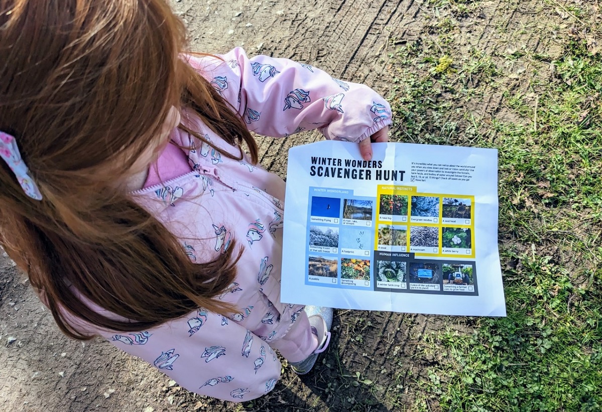 A young girl holds a scavenger hunt sheet for exploring Oxbow Farm & Conservation Center in Carnation near Seattle