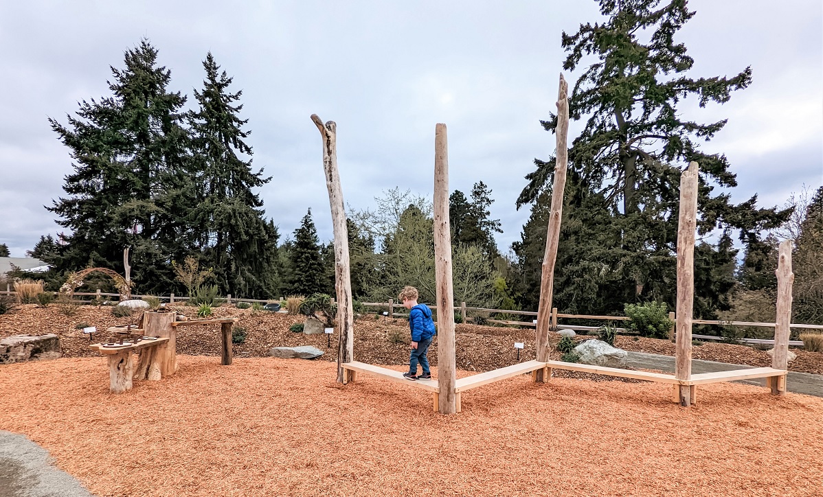 A boy balances on wooden planks in the new Little Explorers Nature Play Garden at Tacoma’s Point Defiance Zoo & Aquarium