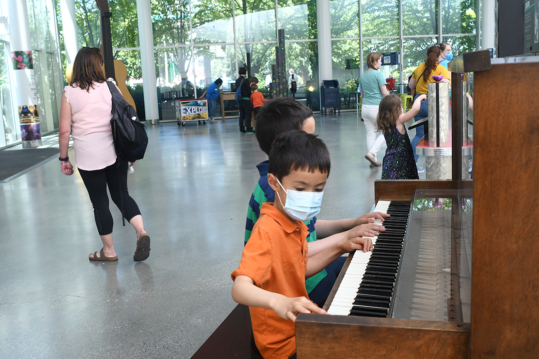 Kids play on instruments in the Carnevali Pavilion, now housing a piano, singing bowls and a giant guitar