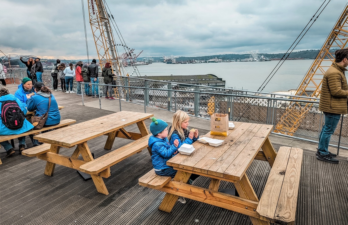 Kids enjoy an outdoor snack at Pike Place Market in Seattle at the newer MarketFront area overlooking Elliot Bay