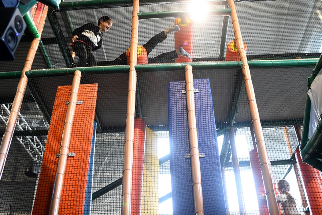 Boys cross high over a parent’s head inside the huge climbing jungle gym at The Ridge Activity Center in Bothell, Wash., near Seattle