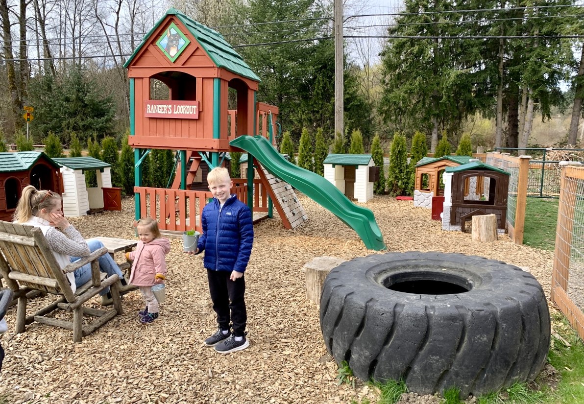 A small play area at Sammamish Animal Sanctuary features a lookout with a slide, a large tire to play on a small play houses