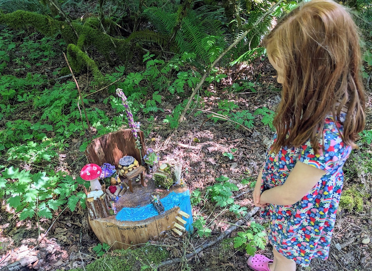 A girl inspects the Sammamish Fairy House Trail a collection of fairy homes set up for summer in Beaver Lake Preserve