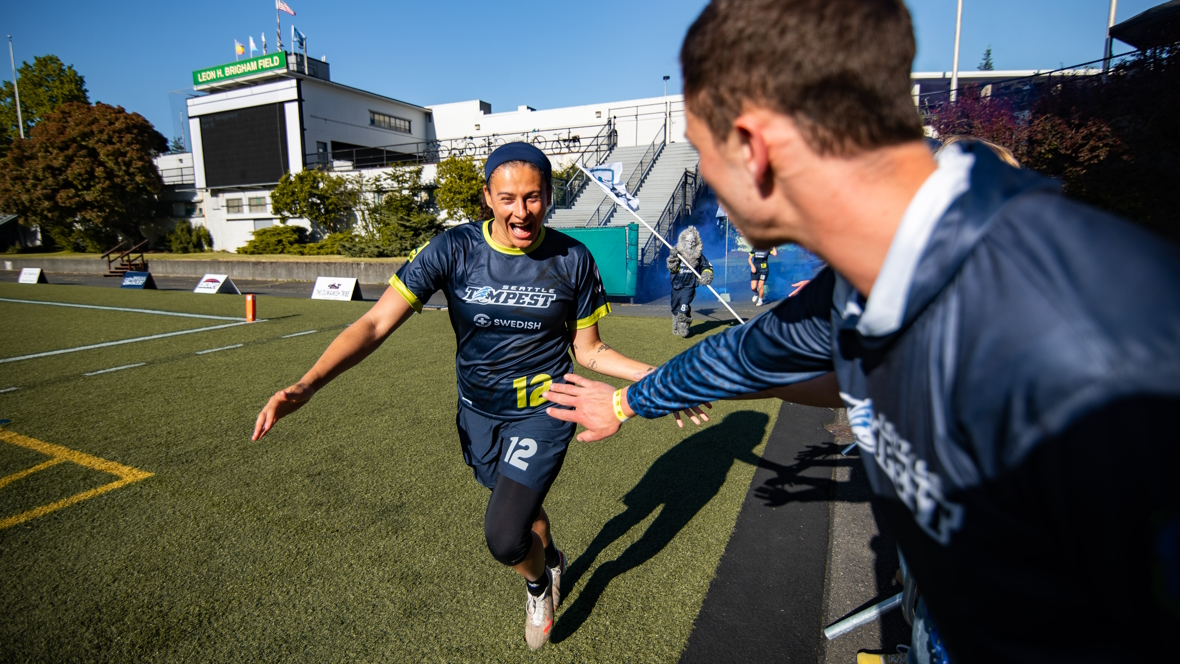 "Seattle Ultimate Frisbee player on the Tempest team gives high fives to the crowd"