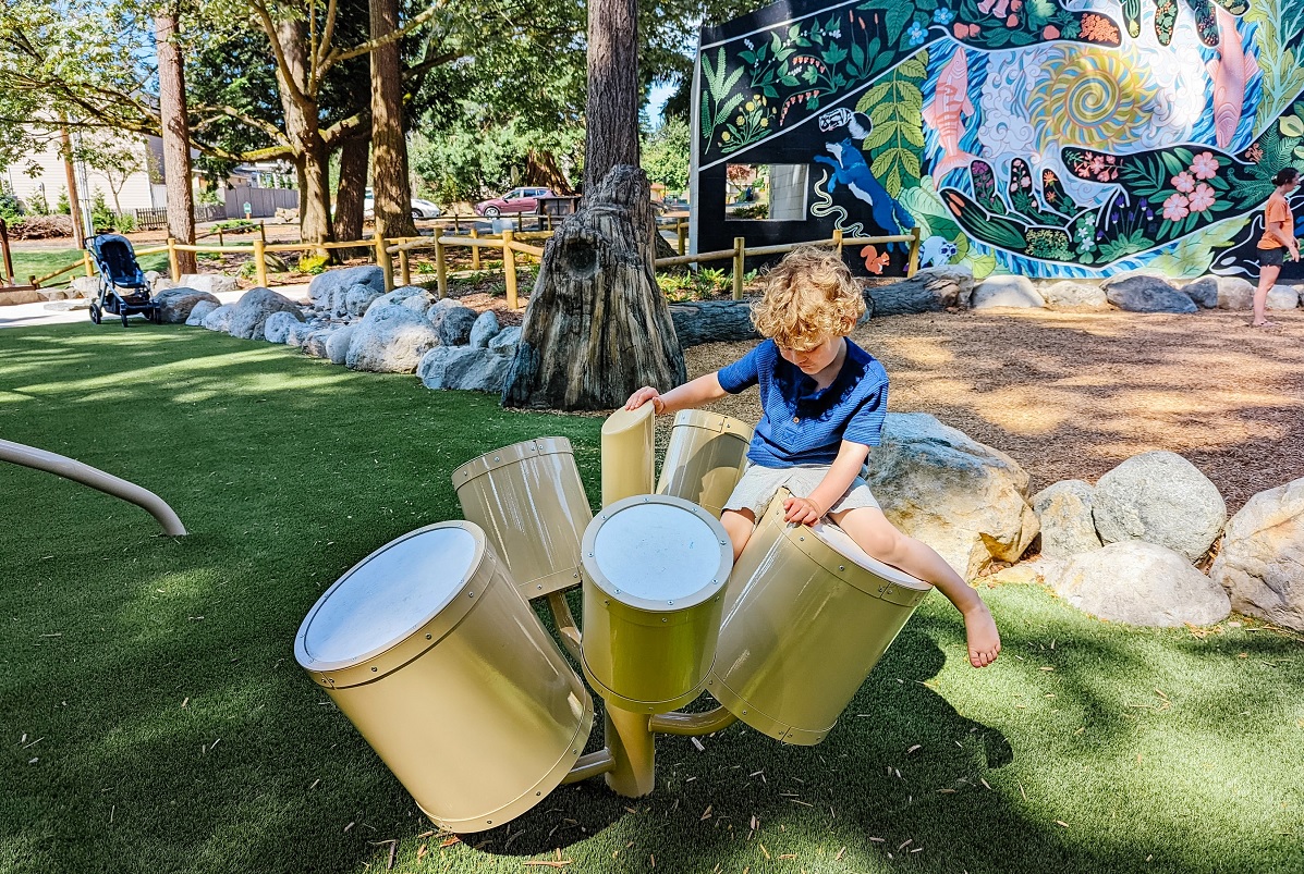 A boys climbs on a play drum kit at the new playground at South Lynnwood Park near Seattle