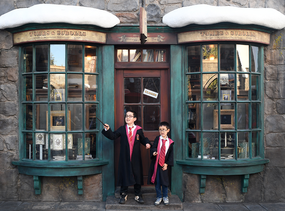 Boys pose in their Hogwarts robes at Universal Studios Hollywood Wizarding World of Harry Potter